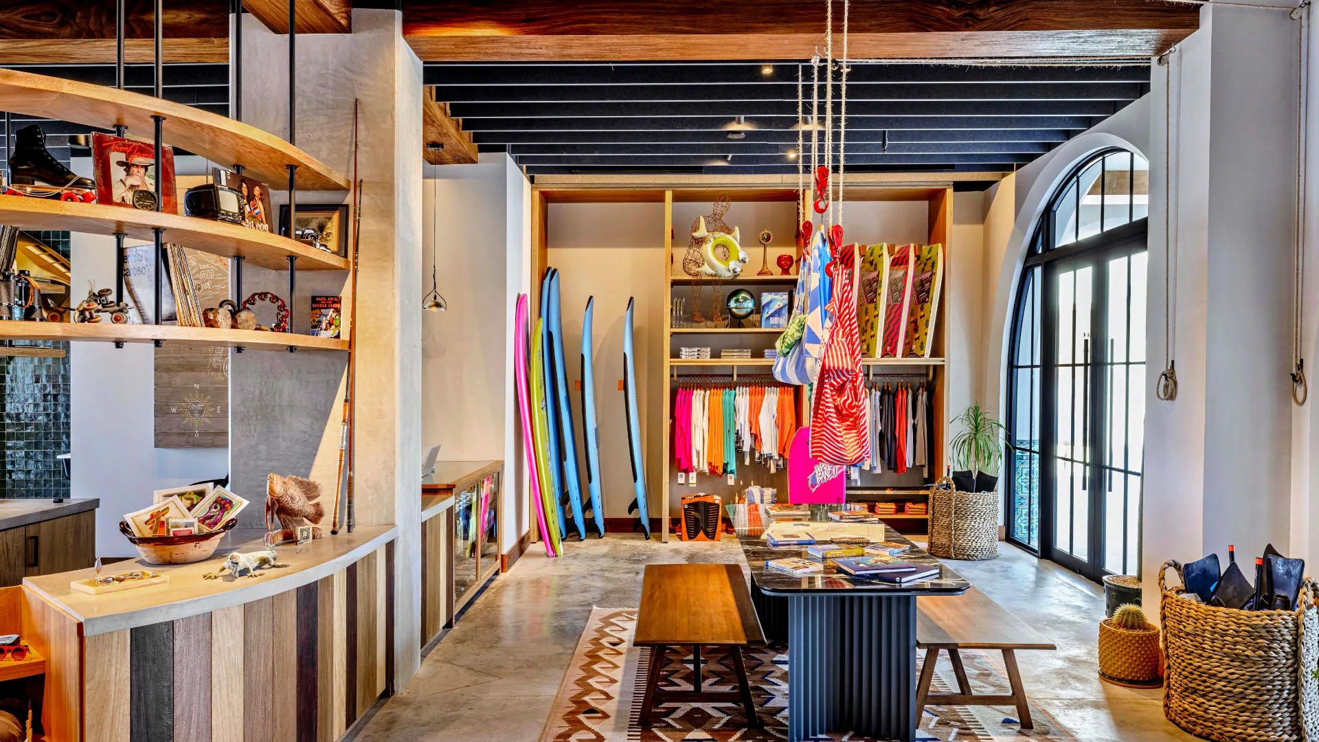 Tienda del Adventure Center en Four Seasons Cabo San Lucas, con tablas de surf y textiles de colores